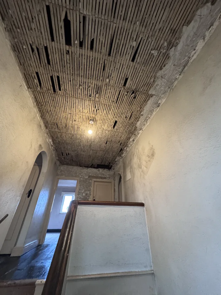 Ceiling after strip-out with timber laths exposed