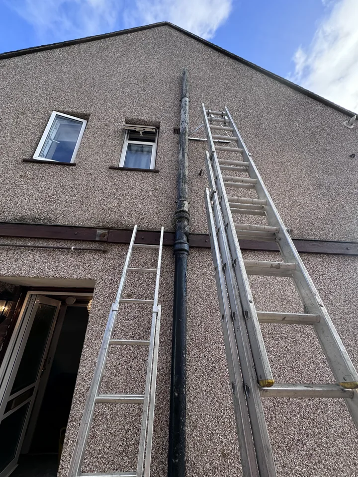 Downpipe attached to the side of a building before removal