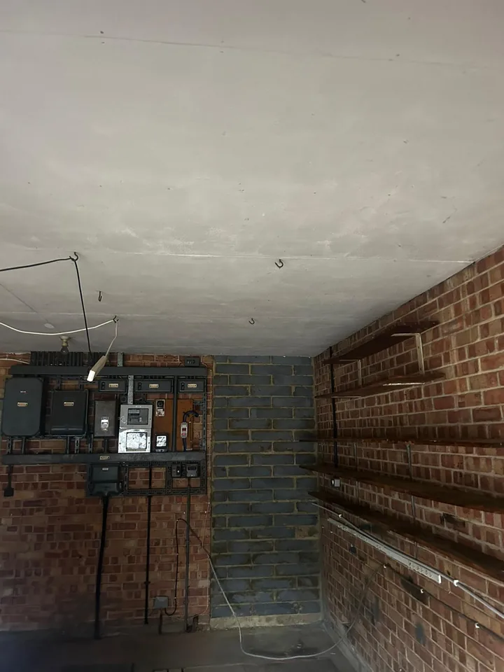 Ceiling and brick walls inside a room before strip-out