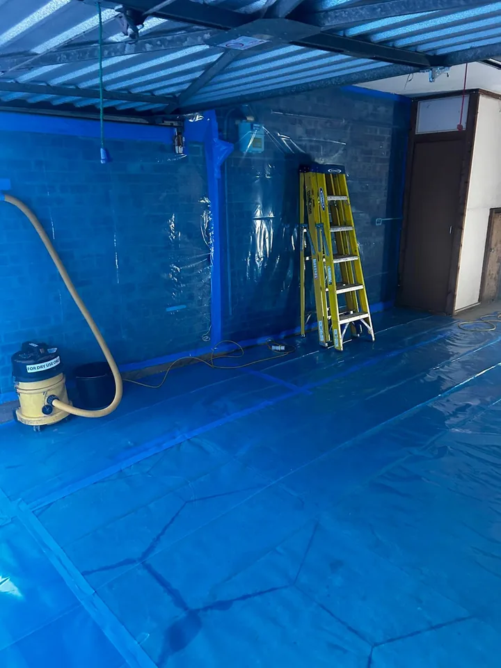 Temporary blue enclosure and ladder inside a room