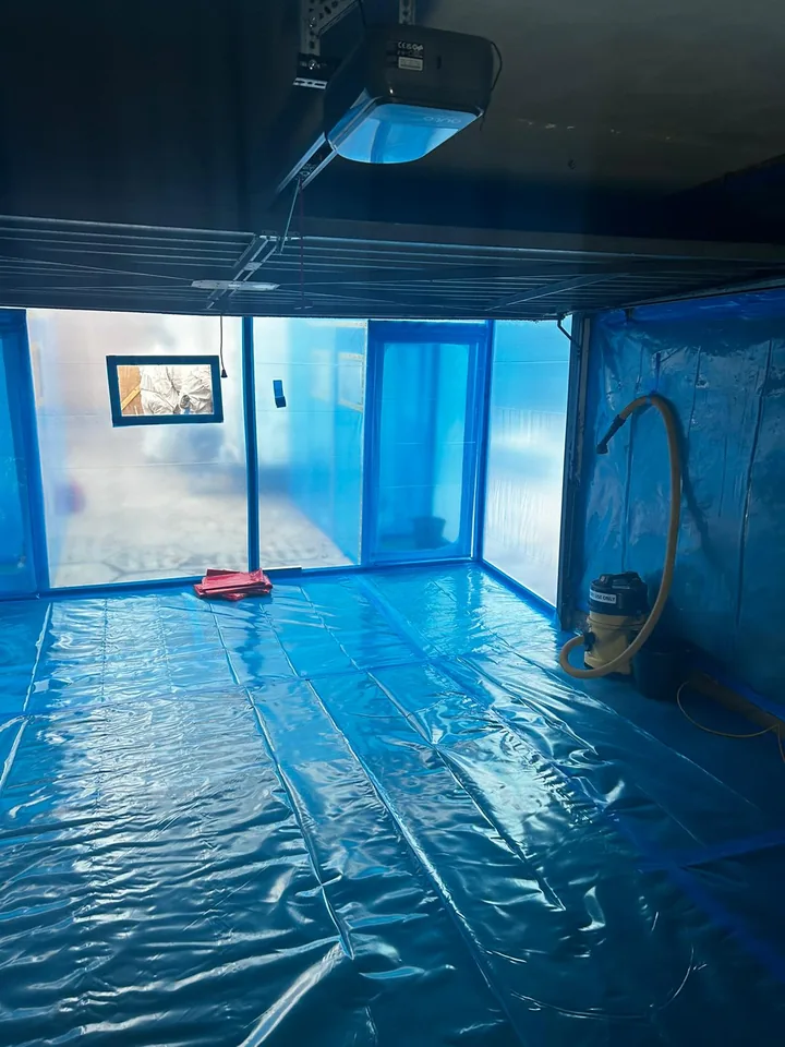 Floor and walls covered with blue sheeting inside an enclosure