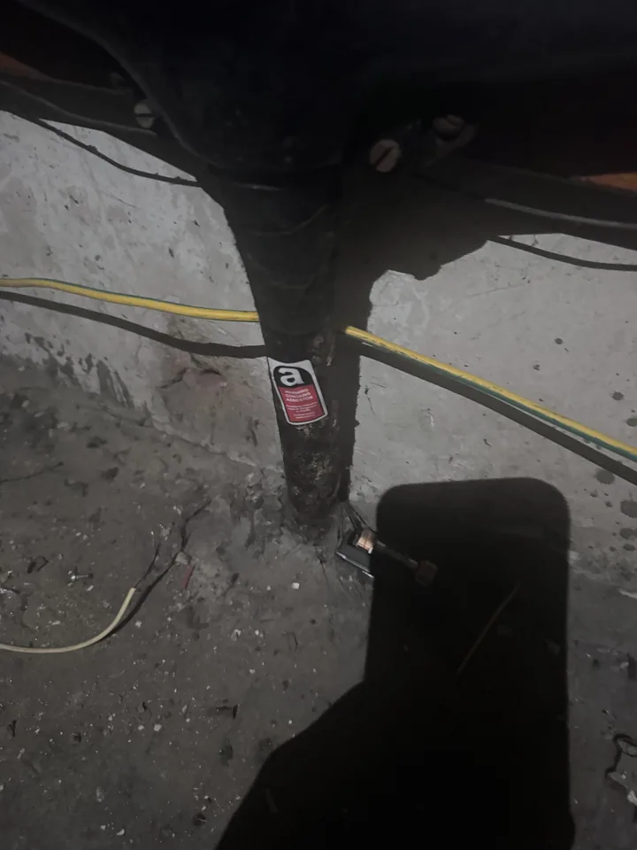 Labelled material near a pipe in a dark inspection area