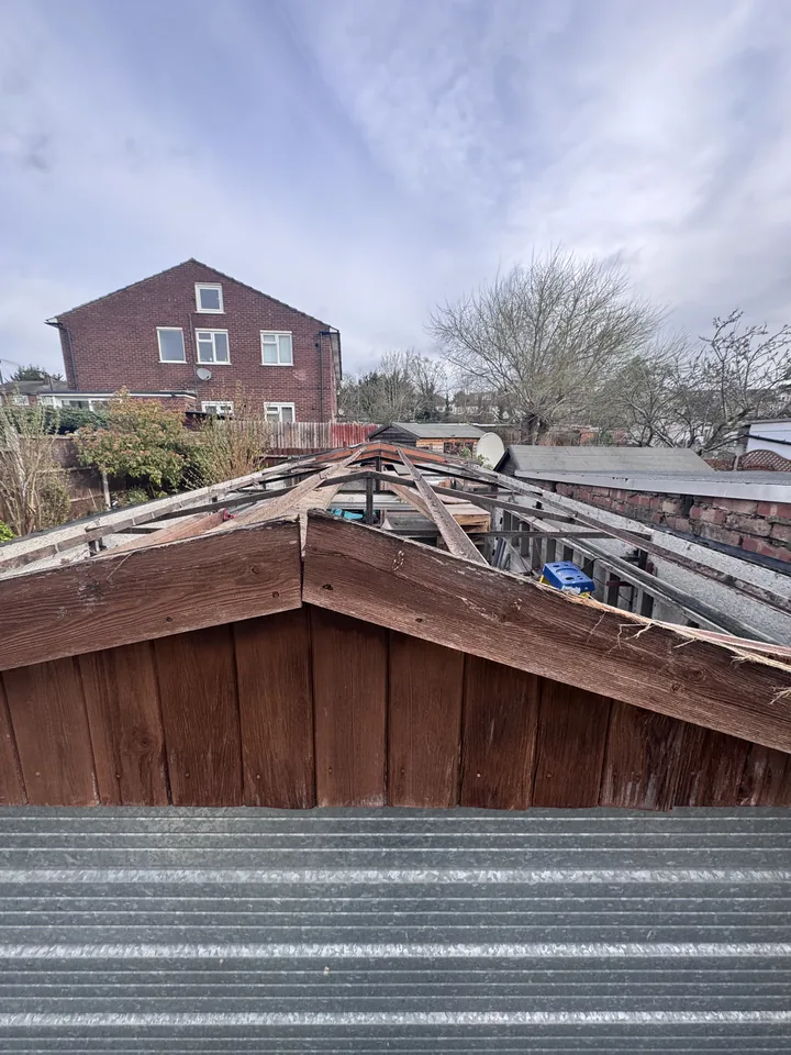Exposed garage roof framing after sheet removal