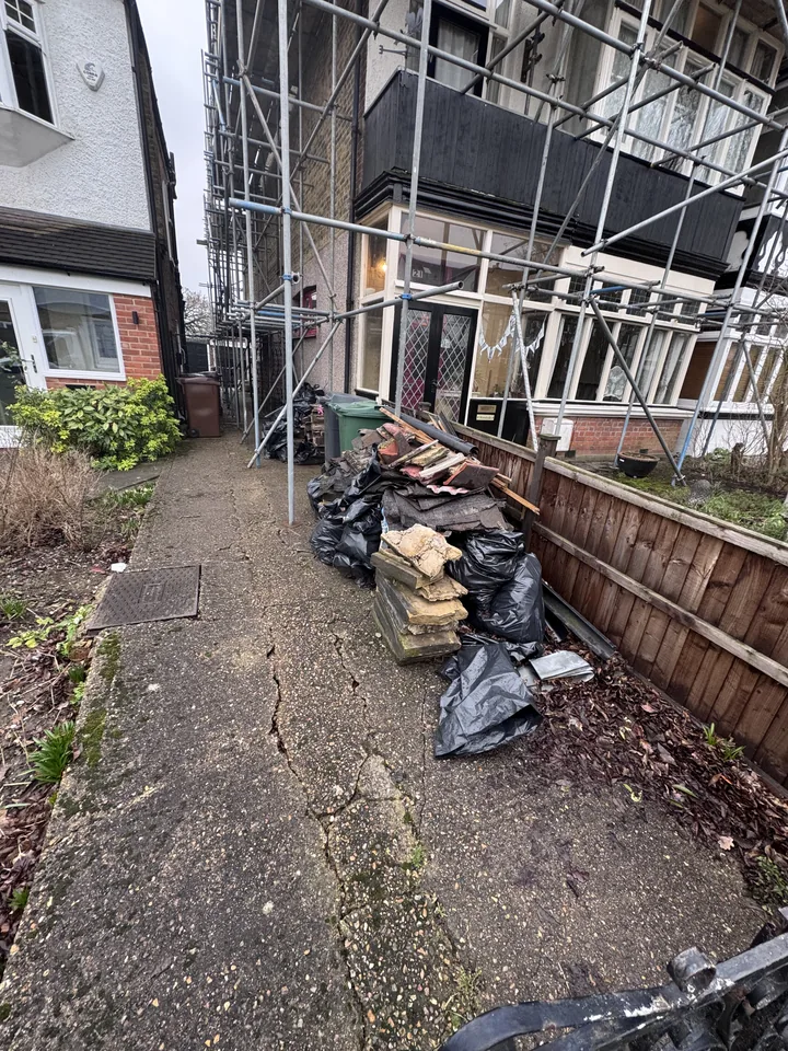 Mixed rubbish beside a building before clearance