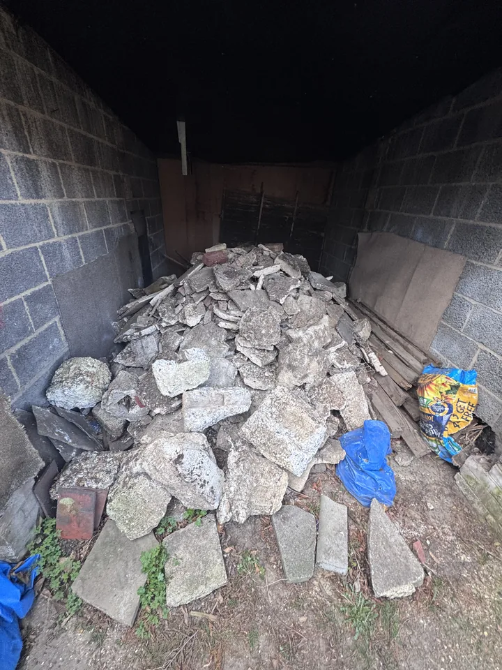 Rubble and mixed debris inside an outbuilding before clearance